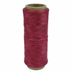 May include: A spool of deep pink waxed thread for leather crafting.