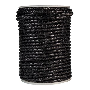 May include: A spool of black braided leather cord. The cord is tightly wound and has a smooth, polished finish.