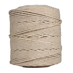 May include: A spool of natural colored cotton rope. The rope is tightly wound and has a natural, rustic look.