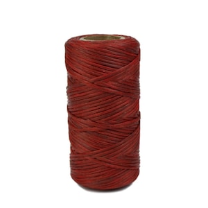 May include: A spool of red waxed thread. The thread is wound tightly around the spool, creating a smooth, even surface.