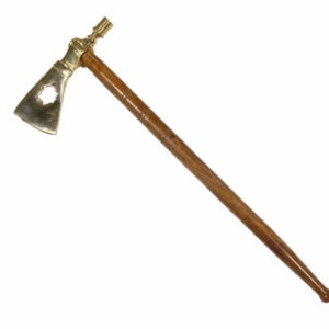 May include: A brass tomahawk with a wooden handle. The tomahawk has a decorative design on the blade.