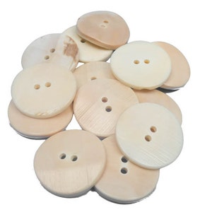 May include: A collection of light beige, round buttons with two holes each. The buttons vary slightly in color and texture, with some showing natural wood grain patterns. Ideal for sewing and craft projects.