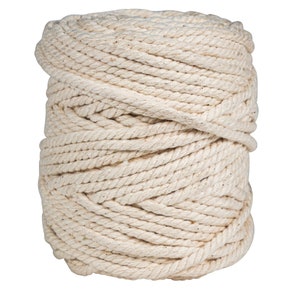 May include: A close-up of a large roll of natural cotton rope. The rope is tightly wound and has a natural, off-white color.