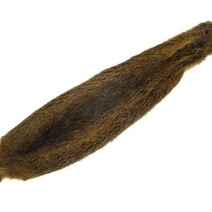 May include: A long, brown fur pelt with a dark brown and light brown color pattern. The fur is soft and fluffy.