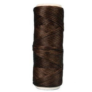 May include: A spool of brown waxed thread for leather crafting.