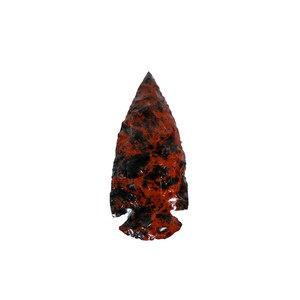 May include: A red and black arrowhead made of stone. The arrowhead has a pointed tip and a wide base.