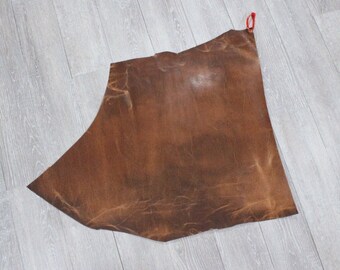 May include: A large piece of brown leather with a slightly textured surface.