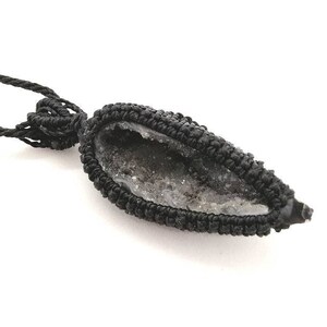 Peut inclure: Collier en cordon noir avec un pendentif en agate noir et gris. Le pendentif a la forme d'une larme et une texture de cristal naturelle.