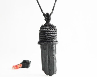 Peut inclure: Collier avec pendentif en tourmaline noire sur un cordon noir. Le cristal est enveloppé de cordon noir en haut.