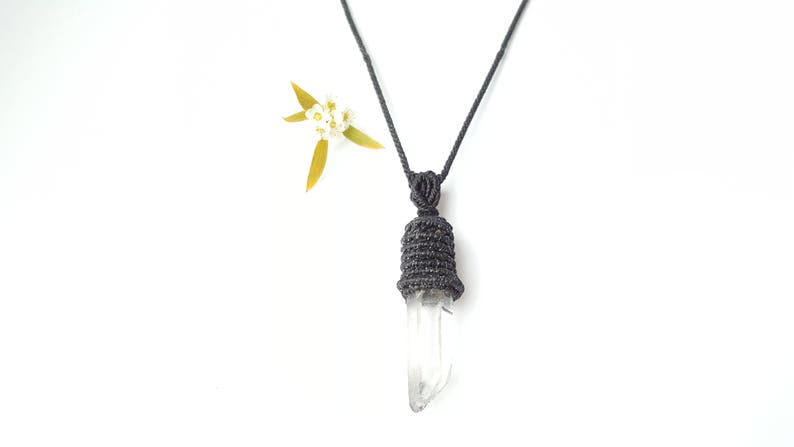 May include: A black cord necklace with a clear quartz crystal pendant wrapped in black cord. The pendant is shaped like a teardrop.