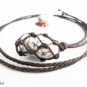 Close up of a tree agate necklace in brown thread