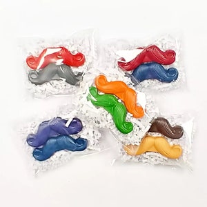 May include: Assortment of colorful mustache shaped crayons packaged individually in clear plastic bags with white shredded paper.