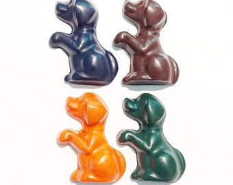 May include: Four small, colorful, plastic dog figurines. The dogs are in a sitting position with their front paws raised. The dogs are blue, brown, orange, and green.
