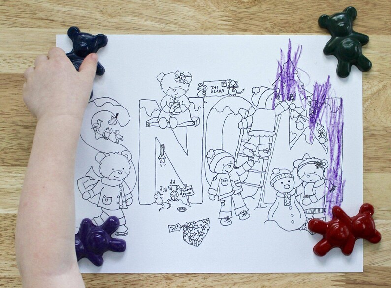 May include: A black and white coloring page with the word "SNOW" written in large letters. The page features illustrations of bears, a ladder, a Christmas tree, and other winter-themed imagery. The page is surrounded by colorful toy bears.