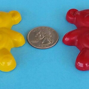May include: Two small teddy bear shaped crayons, one yellow and one red. Both crayons have a heart shape on their chest.