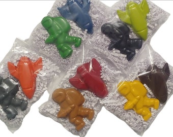 May include: Eight individually packaged crayons shaped like rockets and astronauts. The crayons are in the colors red, orange, yellow, green, blue, black, brown, and dark gray.