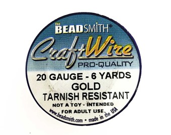 May include: A spool of 20 gauge gold Craft Wire, tarnish resistant, 6 yards long. The spool is labeled "The Beadsmith Craft Wire Pro-Quality".