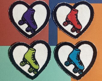May include: Four embroidered iron-on patches in the shape of hearts with roller skate designs. Each heart features a different colored roller skate: purple, red, green, and blue.
