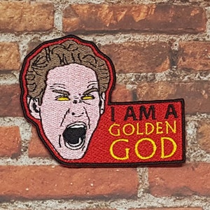 Op de afbeelding: Rode geborduurde patch met een cartoon afbeelding van een man met gele ogen die schreeuwt. De tekst op de patch luidt "I AM A GOLDEN GOD".