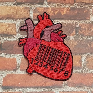 Puede incluir: Corazón anatómico rojo con un código de barras negro impreso en él. El código de barras dice "12345678".