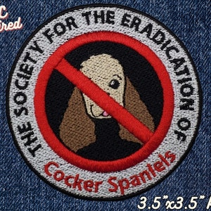 Puede incluir: Un círculo rojo con una línea roja diagonal que lo atraviesa, con fondo blanco y texto negro. El texto dice "The Society for the Eradication of Cocker Spaniels". Dentro del círculo hay una imagen de dibujos animados de un Cocker Spaniel con un pelaje marrón y blanco. El texto "3.5" x 3.5" Patch" está debajo del círculo.