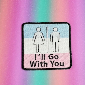 May include: A white and pink embroidered patch with a blue background. The patch features a stylized image of a woman and a man standing side-by-side. The text "I'll Go With You" is written below the figures.