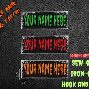 Pode incluir: Três patches bordados de ferro preto e branco com um design de teia de aranha. Os patches medem 8,9 cm de largura e 3,5 cm de altura. O texto nos patches diz "YOUR NAME HERE" em verde, vermelho e laranja. Os patches podem ser costurados, passados a ferro ou presos com velcro.