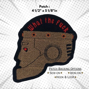 May include: A brown and black embroidered patch with a robot head and the text "What the fuck" in red. The patch is 4 1/2 inches by 5 1/8 inches and has sew-on, iron-on, and hook and loop backing options.