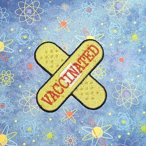 May include: A yellow and red embroidered patch shaped like a bandage with the word "VACCINATED" in red letters.
