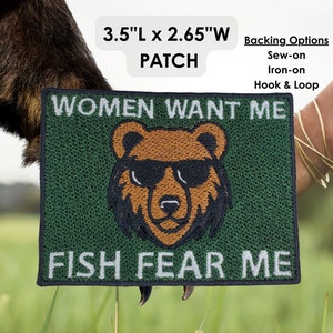 Op de afbeelding: Een groene geborduurde patch met een bruine beer die een zonnebril draagt. De tekst "WOMEN WANT ME" staat boven de beer en "FISH FEAR ME" staat onder de beer. De patch is 3,5 inch lang en 2,65 inch breed.