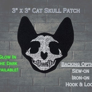 May include: A 3" x 3" black and white cat skull patch with glow-in-the-dark capabilities. The patch has a sew-on, iron-on, or hook and loop backing.