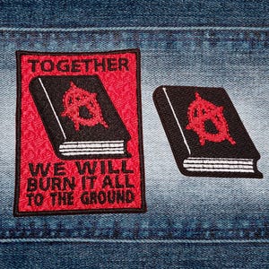 Peut inclure: Deux écussons brodés sur du denim. Un grand écusson avec le texte "TOGETHER WE WILL BURN IT ALL TO THE GROUND" et un livre avec un symbole d'anarchie rouge. Un petit écusson avec le même motif.