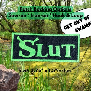 May include: A green and black embroidered patch with the word "SLUT" in green letters. The patch is surrounded by a black border and has a green outline. The text "GET OUT OF MY SWAMP!" is in a speech bubble in the upper right corner of the image. The text "Patch Backing Options Sew-on * Iron-on * Hook & Loop" is at the top of the image. The text "Size: 3.75" x 1.5" inches" is at the bottom of the image.