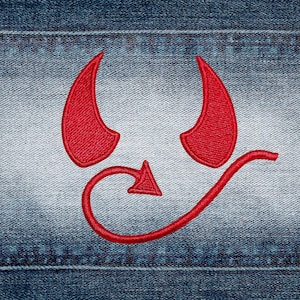 May include: Red devil horns and tail embroidered patch on a denim background. The patch features two curved horns, a pointed arrow, and a curved tail, all in a vibrant red color. The denim has visible stitching.
