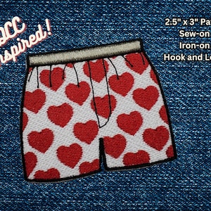 Op de afbeelding: Een witte en rode geborduurde patch van een onderbroek met een hartjespatroon. De patch is 2,5 inch bij 3 inch en kan worden gestikt, gestreken of bevestigd met klittenband.