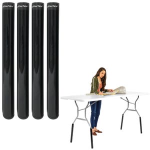 May include: Four black table leg extenders with the text "YourTable" printed on them. A white folding table with metal legs is in the background. A person is standing near the table.