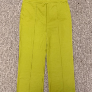 May include: Bright chartreuse-colored pants with a wide-leg design. The pants have a high waist and vertical seams down the front of each leg. The fabric has a slight sheen, and the pants appear to be made of a lightweight material.
