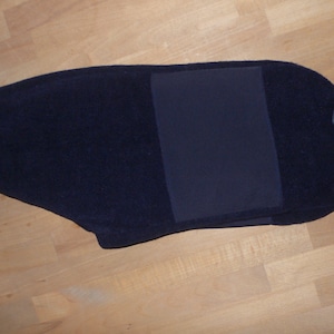 Może przedstawiać: Granatowa bluza z polaru z szarym wykończeniem i czarną naszywką na plecach.