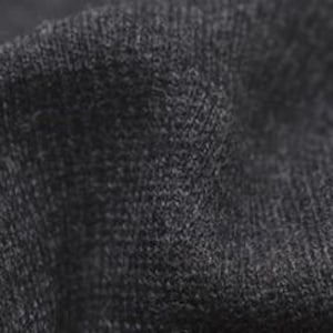 Può includere: Primo piano di un tessuto grigio scuro con una trama testurizzata. Il tessuto ha un aspetto morbido e peloso.