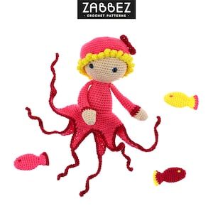 Puede incluir: Una muñeca pulpo de crochet con un cuerpo rosa y tentáculos rojos. El pulpo lleva un vestido rosa y una flor amarilla en la cabeza. Hay tres pequeños peces de crochet en la imagen, dos rosas y uno amarillo.
