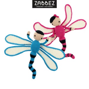 Peut inclure: Deux jouets en crochet en forme de libellule, l'un bleu et l'autre rose, avec des queues rayées de noir et de blanc. Les jouets en forme de libellule ont des ailes blanches avec des bordures bleues et roses.