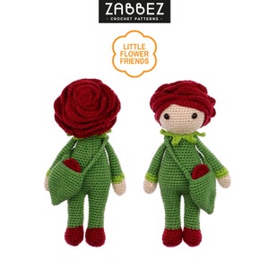 Puede incluir: Una muñeca de crochet con cabeza de rosa roja y cuerpo verde. La muñeca lleva una pequeña bolsa verde con una rosa roja dentro. La muñeca está de pie sobre un fondo blanco. El texto "Little Flower Friends" es visible en la imagen.