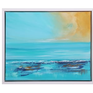 May include: Abstract landscape painting in a white frame. The artwork depicts a turquoise sea and sky, with a golden-yellow area in the upper right. The painting creates a sense of calm and serenity.