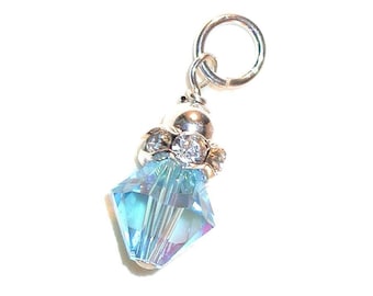 May include: A silver charm featuring a light blue crystal pendant. The crystal is faceted and has a shimmering finish. The charm has a small loop at the top for attaching to a bracelet or necklace.