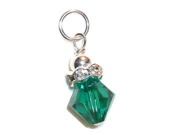 Pode incluir: Um berloque de prata com um pingente de cristal verde. O cristal é facetado e tem uma conta de prata na parte superior. O berloque tem um laço de prata para prender a uma pulseira ou colar.