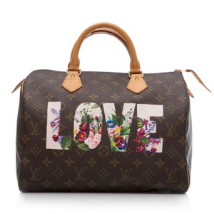 May include: A brown and tan Louis Vuitton handbag with a floral print "LOVE" design.
