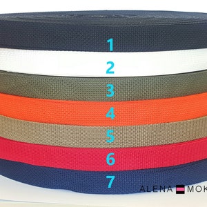 May include: Seven rolls of webbing in different colors, including black, white, olive green, orange, beige, red, and navy blue. The rolls are stacked on top of each other and numbered 1 through 7.