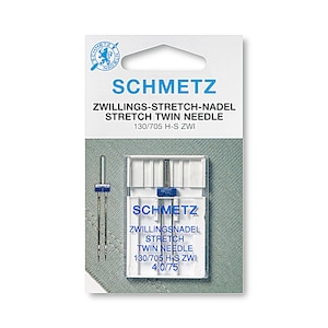 Puede incluir: Un paquete de agujas gemelas de estiramiento Schmetz, tama&ntilde;o 130/705 H-S ZWI, para coser tejidos el&aacute;sticos. El paquete es blanco con texto azul y un logotipo azul. Las agujas est&aacute;n en una caja de pl&aacute;stico transparente.
