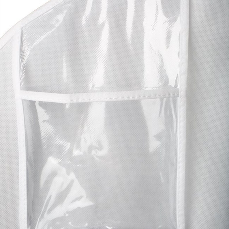 Op de afbeelding: Een witte kledingzak met een transparant plastic venster aan de voorkant. De zak heeft een ritssluiting en een klein transparant plastic zakje aan de voorkant.