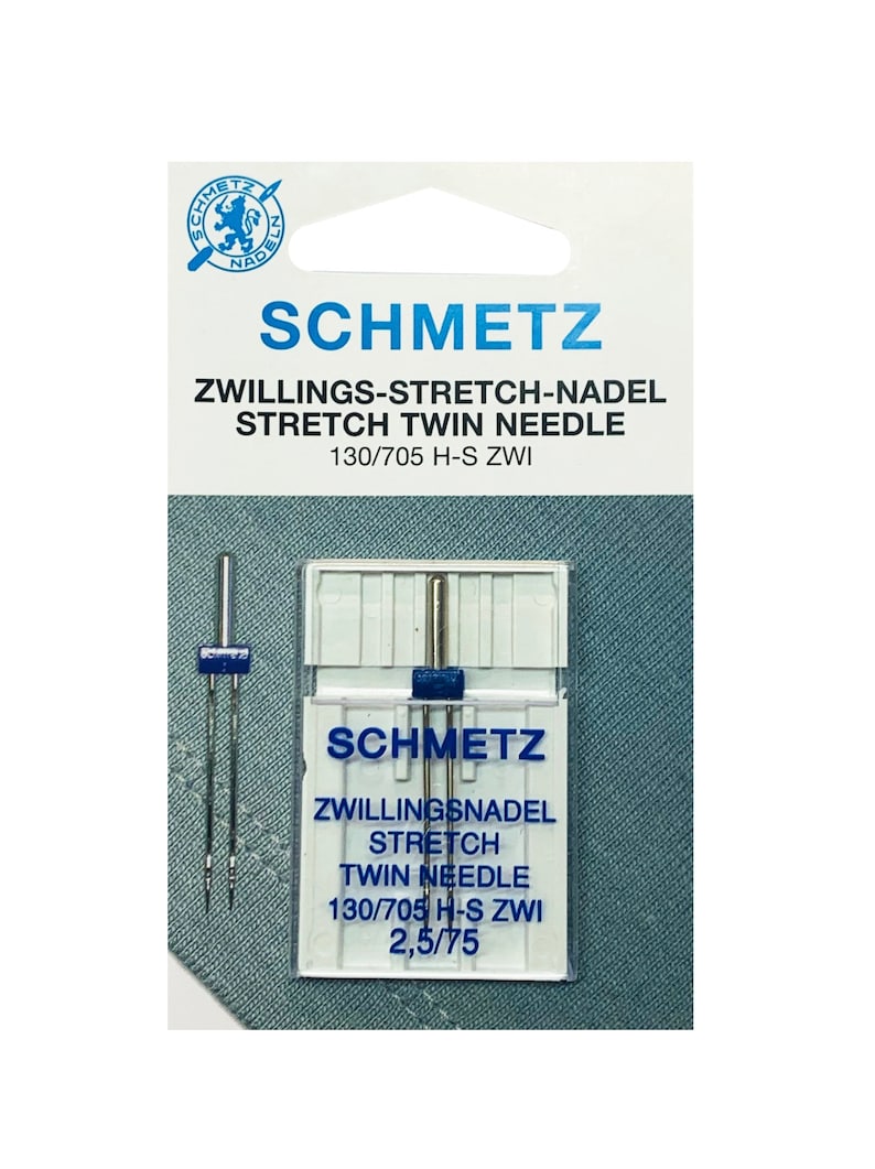 Puede incluir: Un paquete de dos agujas gemelas de estiramiento plateadas para m&aacute;quinas de coser. El paquete est&aacute; etiquetado con "Schmetz" y "Zwillings-Stretch-Nadel Stretch Twin Needle 130/705 H-S Zwi 2,5/75".